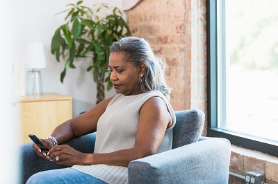 Businesswoman takes break to read emails on smart phone